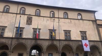 Bandiera Croce Rossa su facciata Palazzo dei Priori in occasione della Giornata mondiale della Croce rossa e Mezza luna rossa